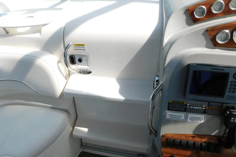 Slide: The Image of 2009 Bayliner 300 boat cockpit with control panel and seating area. - 38
