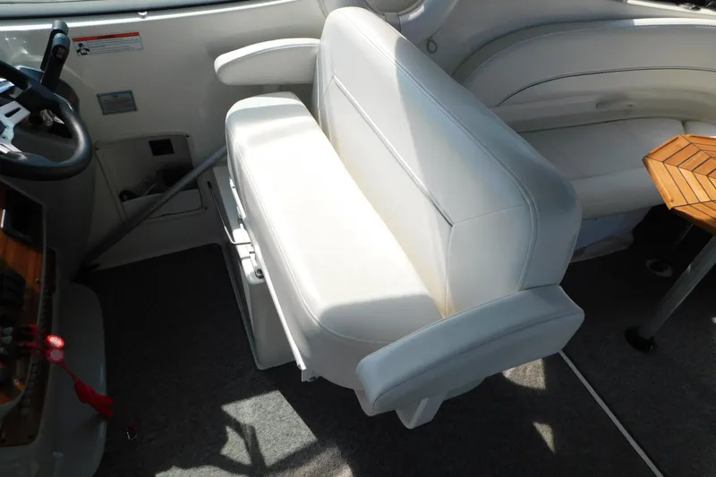 Slide: The Image of Interior of 2009 Bayliner 300 boat with white seating and wooden table. - 29