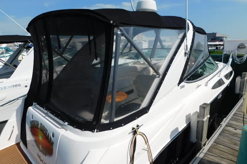 Slide: The Image of 2009 Bayliner 300 boat docked, featuring a sleek design and enclosed cockpit. - 5