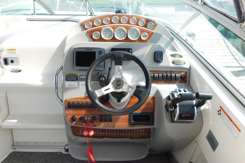 Slide: The Image of 2009 Bayliner 300 boat dashboard with steering wheel and control panel. - 32