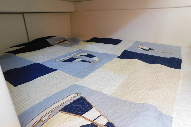 Slide: The Image of Cozy cabin bed with nautical-themed quilt in 2009 Bayliner 300 boat. - 83