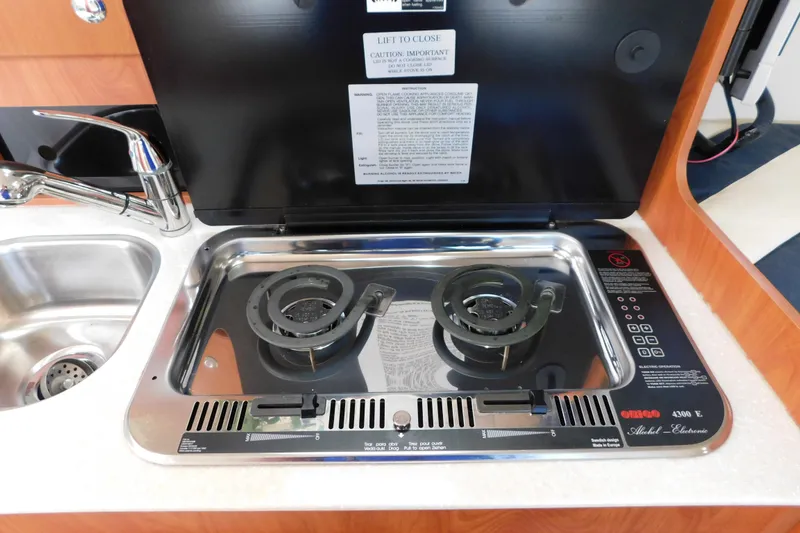 Slide: The Image of 2009 Bayliner 300 yacht kitchen with dual-burner stove and stainless steel sink. - 60