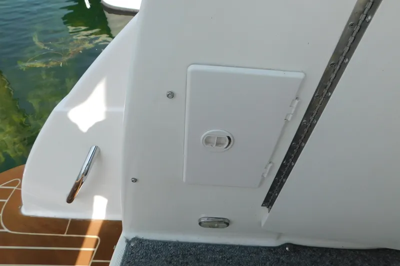 Slide: The Image of 2009 Bayliner 300 boat deck with white hatch and chrome handle. - 16
