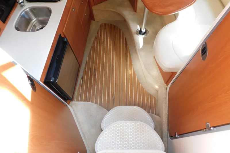Slide: The Image of Interior of 2009 Bayliner 300 boat with kitchenette and seating area. - 47
