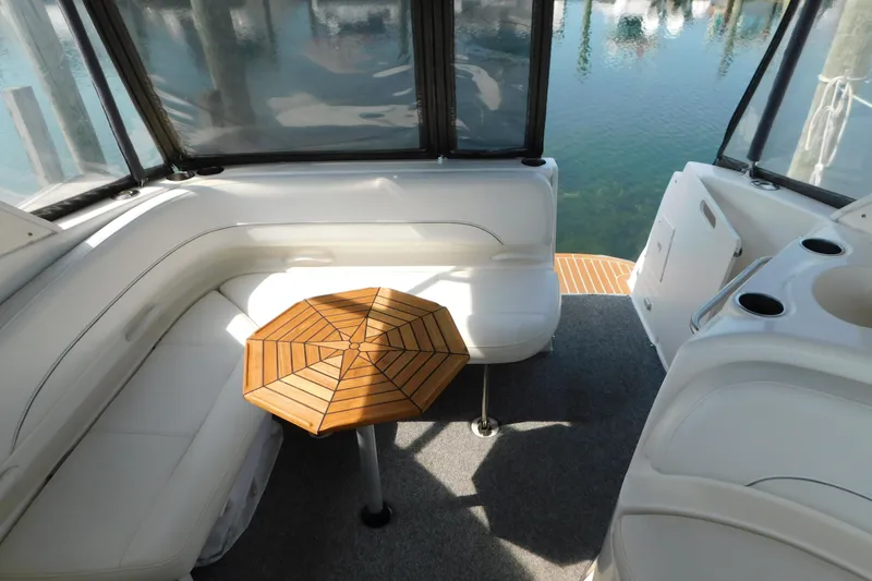 Slide: The Image of Interior of 2009 Bayliner 300 boat with seating and wooden table. - 26