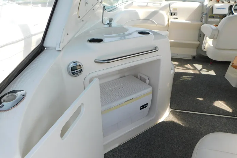 Slide: The Image of 2009 Bayliner 300 interior with cooler storage and seating area. - 19