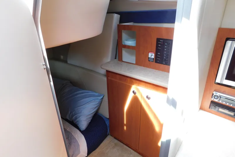 Slide: The Image of Interior cabin of a 2009 Bayliner 300 boat with cozy bedding and wooden cabinetry. - 79