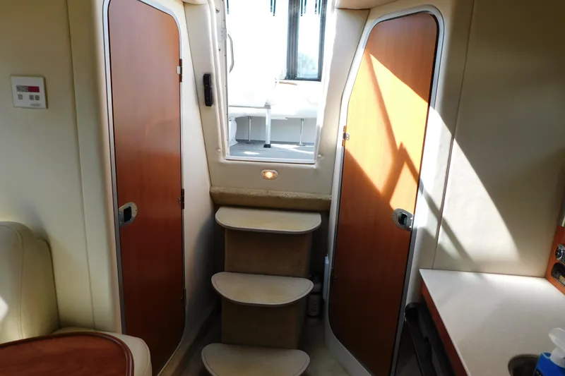 Slide: The Image of Interior of 2009 Bayliner 300 boat with wooden doors and carpeted steps. - 78