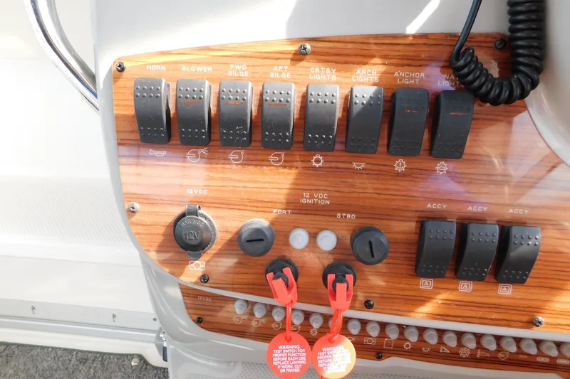 Slide: The Image of Control panel of a 2009 Bayliner 300 boat with various switches and dials. - 37