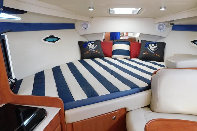 Slide: The Image of Interior of 2009 Bayliner 300 boat with striped bedding and nautical-themed pillows. - 54