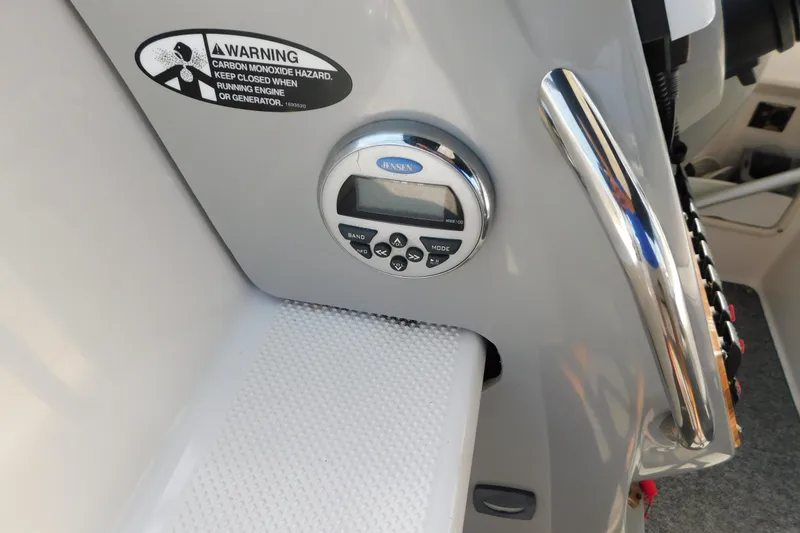 Slide: The Image of Control panel of a 2009 Bayliner 300 boat with warning label and radio display. - 46
