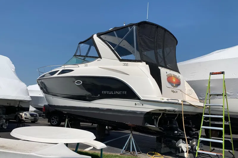 Slide: The Image of 2009 Bayliner 300 boat on dry dock, with protective cover and ladder nearby. - 11
