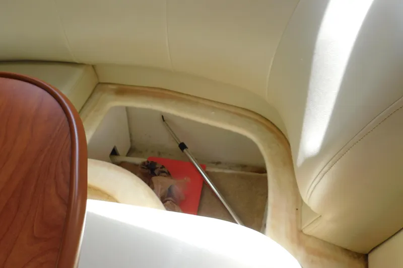 Slide: The Image of Interior storage compartment of a 2009 Bayliner 300 boat with beige seating. - 73