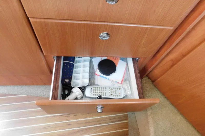 Slide: The Image of Open drawer in 2009 Bayliner 300 boat with remote controls and miscellaneous items. - 70