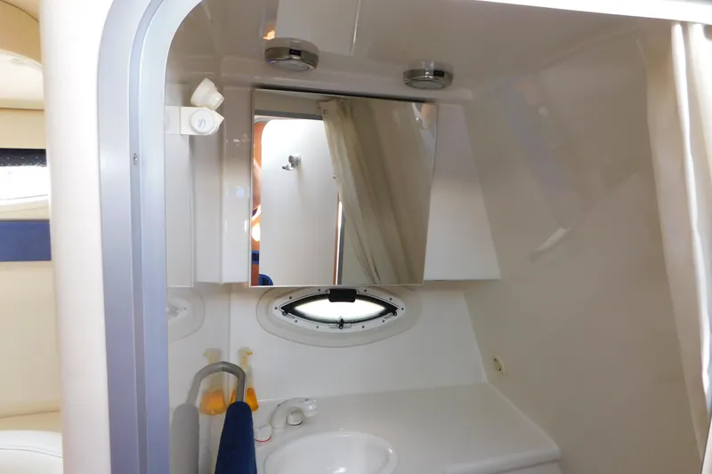 Slide: The Image of 2009 Bayliner 300 boat bathroom with mirror, sink, and porthole window. - 87