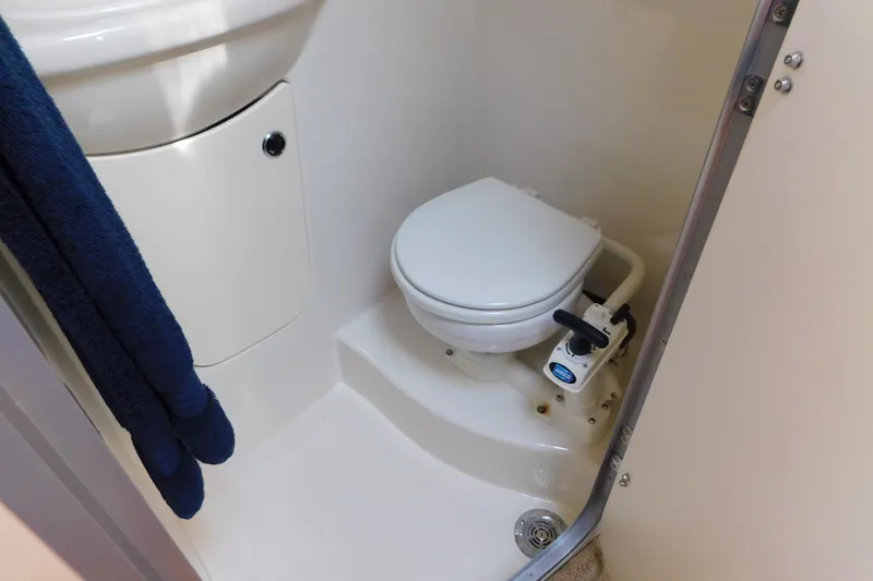 Slide: The Image of Compact bathroom in 2009 Bayliner 300 boat with marine toilet and blue towel. - 85