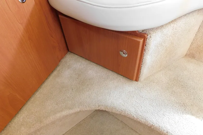 Slide: The Image of Interior of 2009 Bayliner 300 boat, featuring wooden cabinetry and plush carpet flooring. - 74