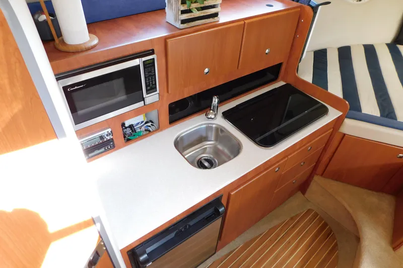 Slide: The Image of 2009 Bayliner 300 boat interior kitchen with microwave, sink, and countertop. - 50