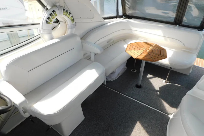 Slide: The Image of Interior of 2009 Bayliner 300 boat with white seating and wooden table. - 31