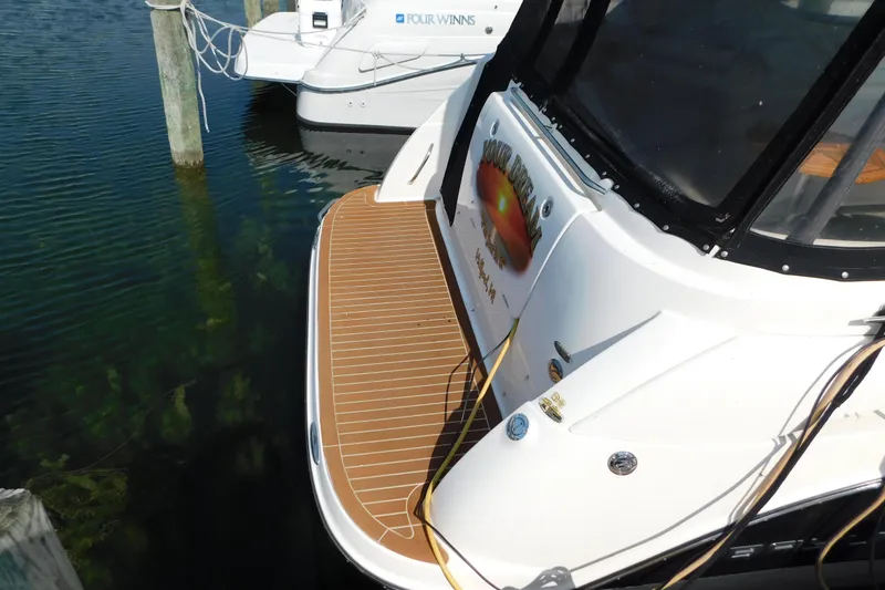 Slide: The Image of 2009 Bayliner 300 boat docked, featuring a spacious swim platform and sleek design. - 6