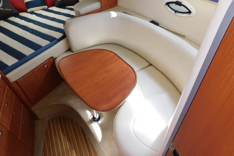 Slide: The Image of 2009 Bayliner 300 interior with curved seating and wooden table. - 48
