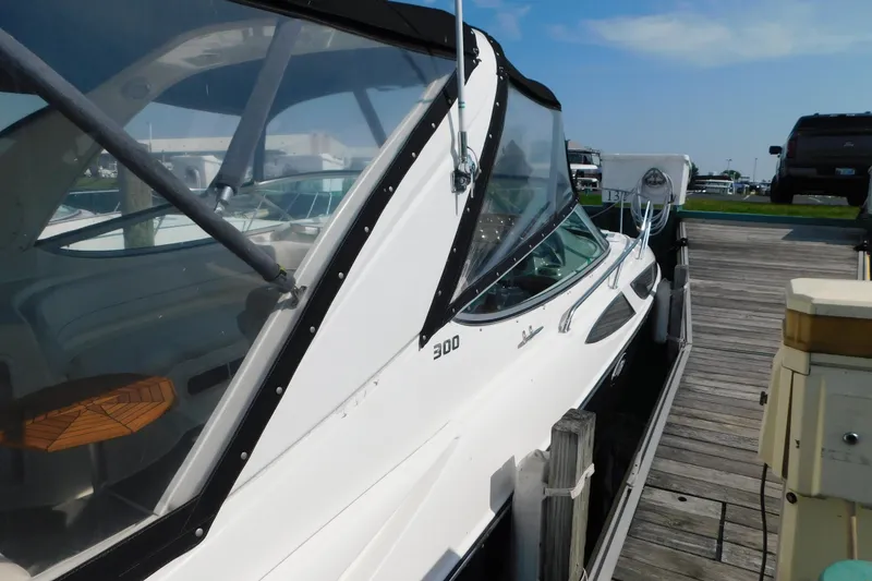 Slide: The Image of 2009 Bayliner 300 boat docked at marina under clear blue sky. - 12