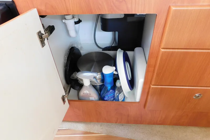 Slide: The Image of Open cabinet in 2009 Bayliner 300 boat, storing cleaning supplies and kitchen items. - 67