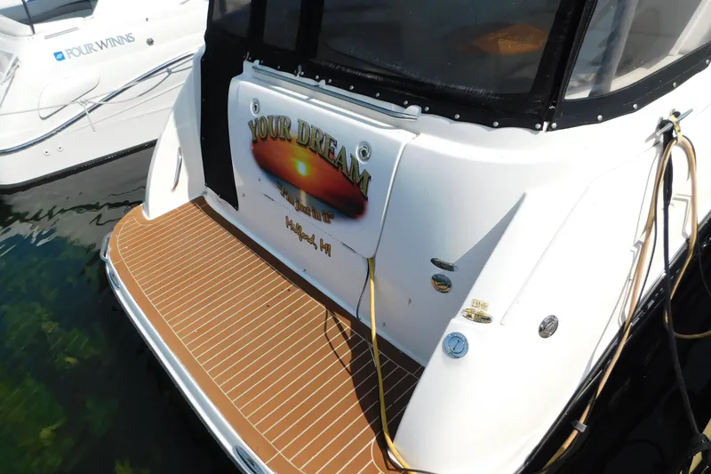 Slide: The Image of 2009 Bayliner 300 boat docked, featuring "Your Dream" nameplate and wooden deck. - 7