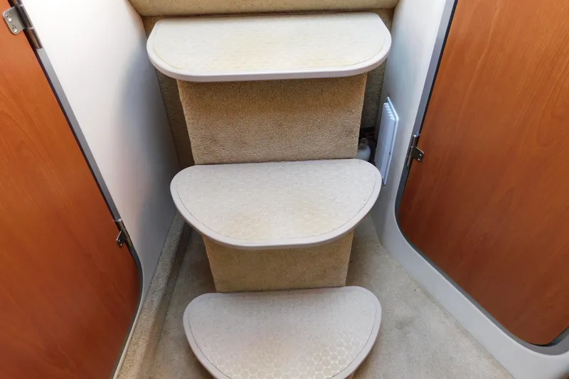Slide: The Image of Carpeted stairs inside a 2009 Bayliner 300 boat cabin. - 89