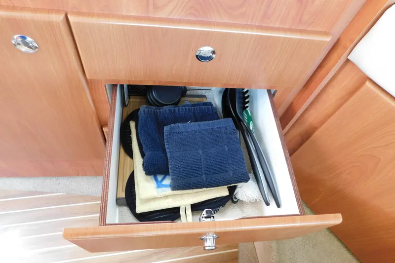 Slide: The Image of Open drawer in 2009 Bayliner 300 boat with towels and cleaning supplies. - 69