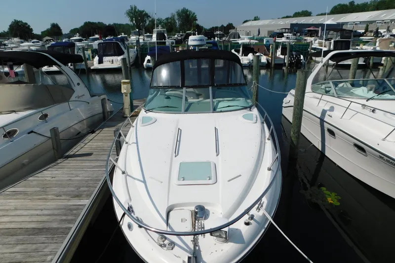 Slide: The Image of 2009 Bayliner 300 boat docked at marina, surrounded by other vessels. - 2