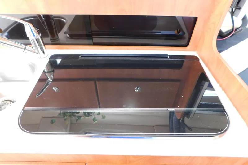 Slide: The Image of 2009 Bayliner 300 yacht kitchen with sleek black stove and modern faucet. - 59