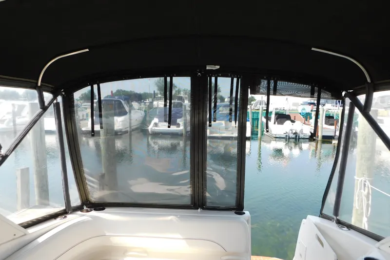 Slide: The Image of Interior view from a 2009 Bayliner 300 boat, overlooking a marina with docked boats. - 27