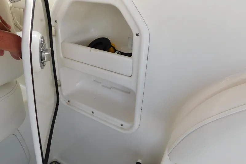 Slide: The Image of Open storage compartment on 2009 Bayliner 300 boat, showing interior space and latch. - 25