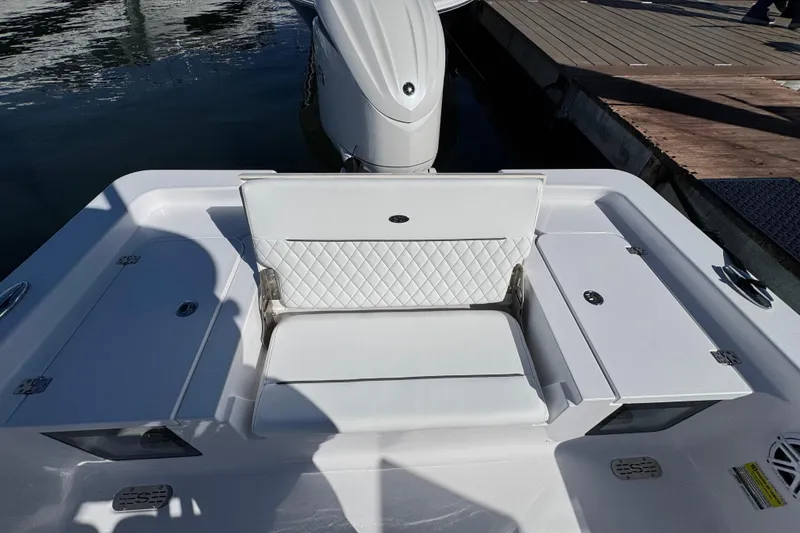 Slide: The Image of 2024 Sportsman Masters 247 Bay Boat with white seating and storage compartments. - 6
