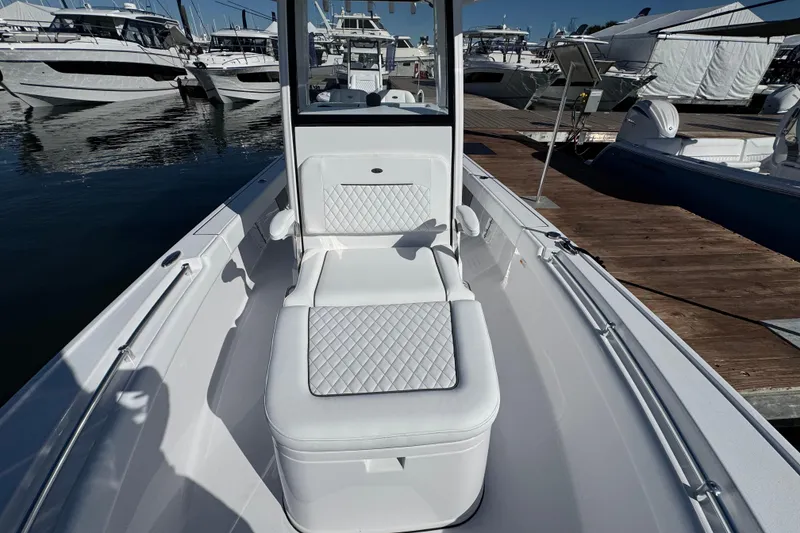 Slide: The Image of 2024 Sportsman Masters 247 Bay Boat interior with cushioned seating at marina. - 10