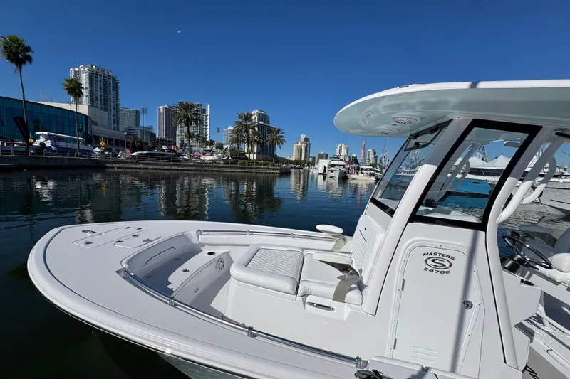 Slide: The Image of 2024 Sportsman Masters 247 Bay Boat docked in a scenic urban marina. - 4