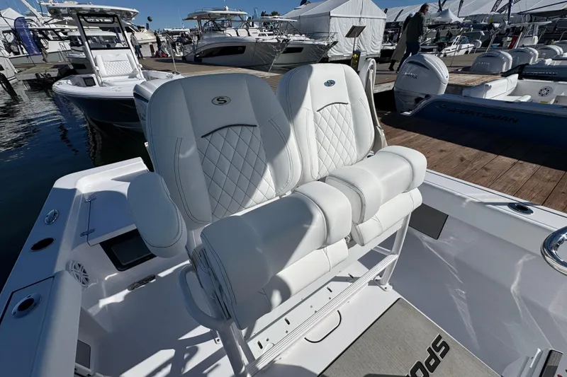 Slide: The Image of 2024 Sportsman Masters 247 Bay Boat with luxurious white seating at a marina. - 8