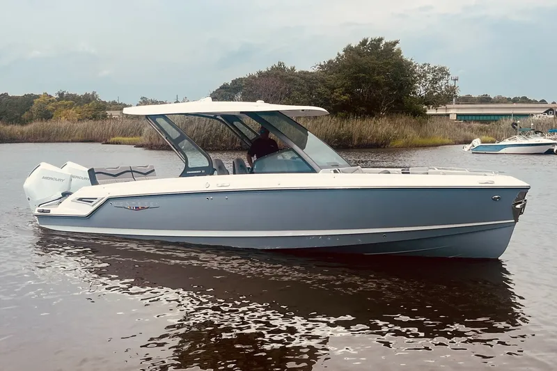 Slide: The Image of 2027 Monterey Elite 30 OB boat on calm water, featuring sleek design and modern outboard engines. - 1