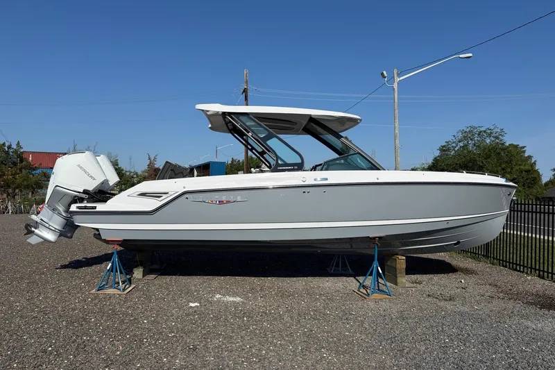 The Image of 2027 Monterey Elite 30 OB boat on stands, side view, outdoors. - 0