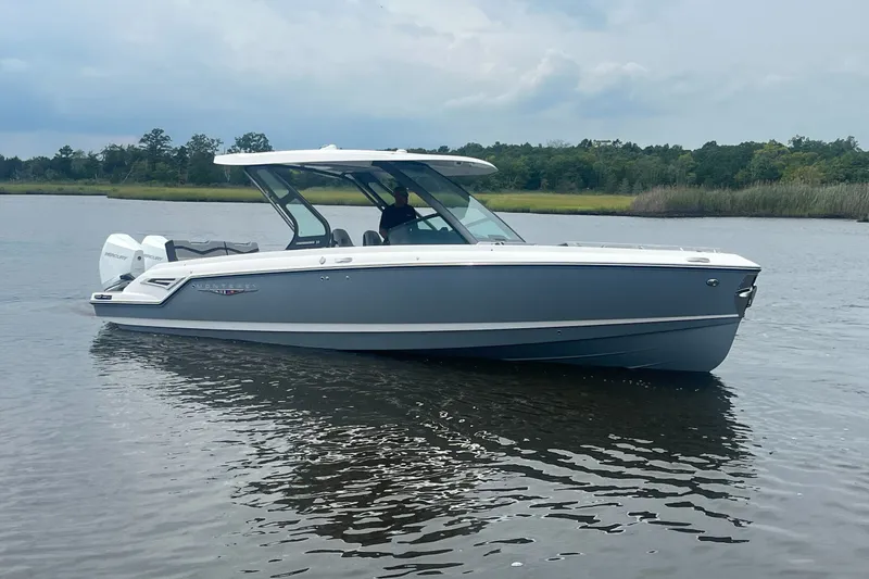 Slide: The Image of A sleek gray boat floating calmly on a river, surrounded by trees. - 2