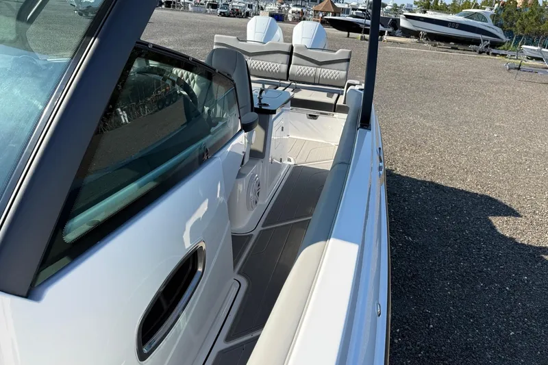 Slide: The Image of 2027 Monterey Elite 30 OB boat, sleek design, spacious seating, parked outdoors. - 6