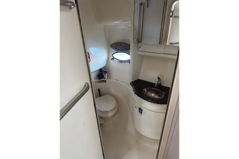 Slide: The Image of Compact bathroom in 2003 Formula 37 Performance Cruiser with sink, toilet, and porthole window. - 52