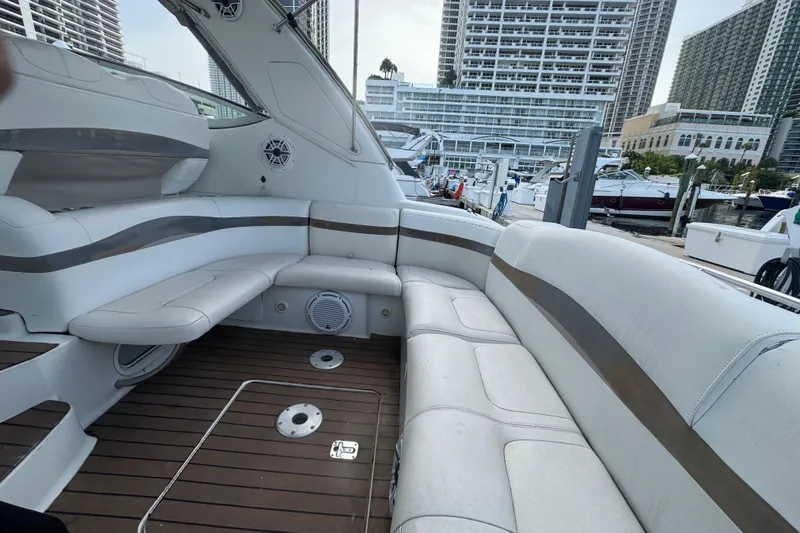 Slide: The Image of 2003 Formula 37 Performance Cruiser interior with white seating and wooden deck at marina. - 19
