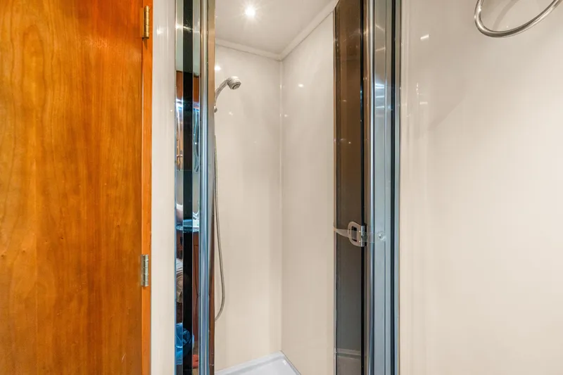Slide: The Image of Shower area in 2005 Cruisers Yachts 520 Express with wooden door and glass enclosure. - 21