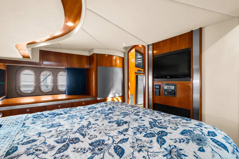 Slide: The Image of Luxurious 2005 Cruisers Yachts 520 Express cabin with elegant wood finishes and floral bedding. - 19