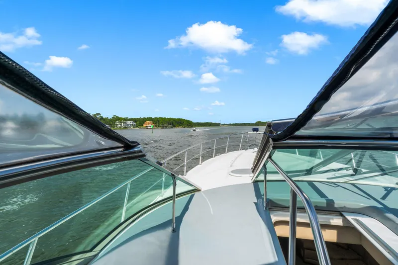 Slide: The Image of 2005 Cruisers Yachts 520 Express navigating a scenic waterway under a clear blue sky. - 30