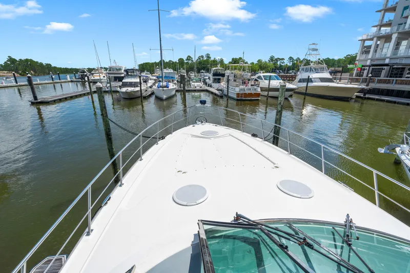 Slide: The Image of 2005 Cruisers Yachts 520 Express docked at a marina with other boats. - 28