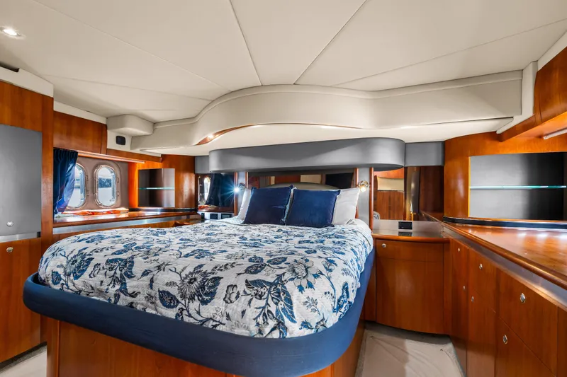 Slide: The Image of Luxurious 2005 Cruisers Yachts 520 Express cabin with elegant wood finishes and floral bedding. - 15