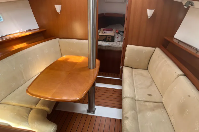 Slide: The Image of Interior of 2006 Beneteau Oceanis Clipper 373 with wooden table and beige seating. - 15